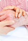 caregiver holding her patient's hand